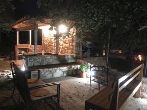 a group of chairs and a stone bench at night at Janakis Garden Livadi Beach in (( Spile ))