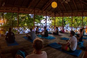 un gruppo di persone sedute a lezione di yoga di Siladen Resort & Spa a Bunaken