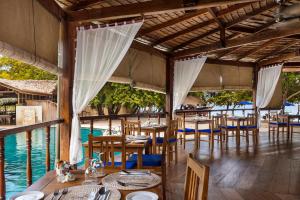 ブナケンにあるシラデン リゾート ＆ スパの水辺のテーブルと椅子が備わるレストラン