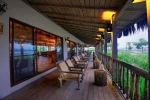 a row of chairs sitting on a porch at Barahi Jungle Lodge in Meghauli