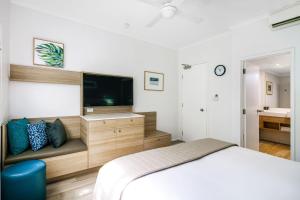 
a bedroom with a bed and a television at Mantra PortSea in Port Douglas
