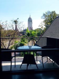 a balcony with a table and chairs and a building at iuDia Hotel in Phra Nakhon Si Ayutthaya