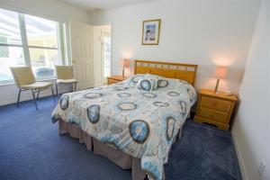 a bedroom with a bed with a flowered comforter at Villa Lovie - Family & Golf vacations in Inverness +31 photos