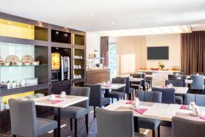 a restaurant with tables and chairs and a kitchen at Best Western Hôtel Journel Antibes Juan-les-Pins in Antibes