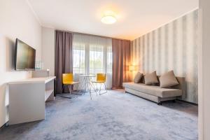 a living room with a couch and a table at Hotel Perłowy in Okuninka