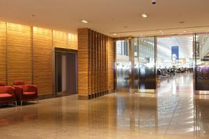 a lobby of a building with red chairs and a hallway at Haneda Excel Hotel Tokyu Haneda Airport Terminal 2 in Tokyo