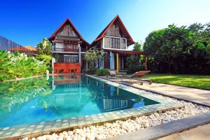 a house with a swimming pool in front of it at iuDia Hotel in Phra Nakhon Si Ayutthaya