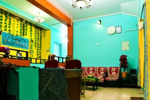 a restaurant with blue walls and chairs and a clock at RK Holiday Home in Ooty