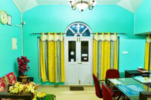 a dining room with blue walls and a white door at RK Holiday Home in Ooty
