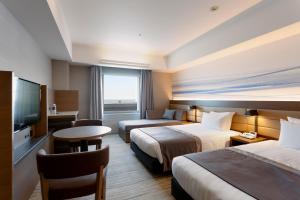 a hotel room with two beds and a television at Haneda Excel Hotel Tokyu Haneda Airport Terminal 2 in Tokyo