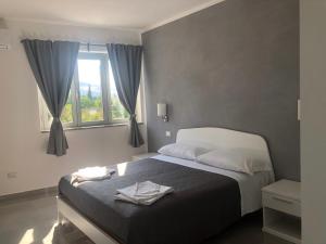 a bedroom with a large bed with a window at Roseto Mare B&B in Roseto Capo Spulico