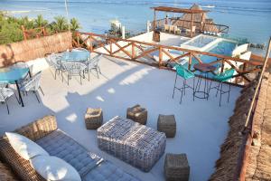 un patio con sillas, mesas y una piscina en Spirit Holbox en Holbox Island