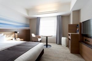 a hotel room with a bed and a table and a tv at Haneda Excel Hotel Tokyu Haneda Airport Terminal 2 in Tokyo