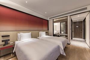 Postel nebo postele na pokoji v ubytování Joya Shanghai Xujiahui Hotel