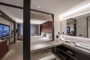 Postel nebo postele na pokoji v ubytování Joya Shanghai Xujiahui Hotel