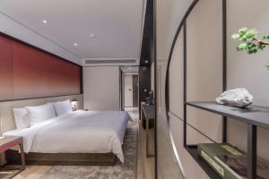Postel nebo postele na pokoji v ubytování Joya Shanghai Xujiahui Hotel
