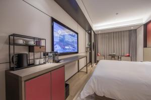Postel nebo postele na pokoji v ubytování Joya Shanghai Xujiahui Hotel