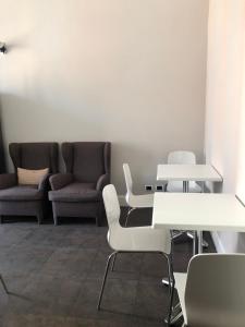 una sala d'attesa con tavoli e sedie bianchi di Guest House Cavour 278 a Roma