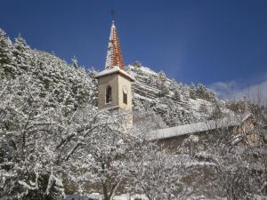 une tour d'horloge au sommet d'une montagne enneigée dans l'établissement Gîte Belle Valette, à Prads-Haute-Bléone