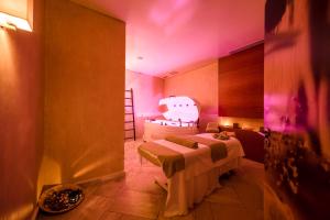 a room with two beds in a room with pink lights at Sesimbra Oceanfront Hotel - Preferred Hotels and Resorts in Sesimbra