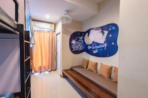 Zimmer mit Sofa und Schild an der Wand in der Unterkunft Restiny Hostel in Bangkok