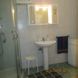 y baño con lavamanos, ducha y taburete. en Masseria San Vito, en Copertino