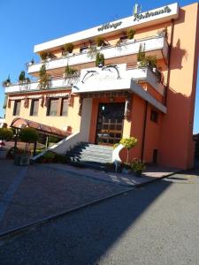 ノヴァーラにあるAlbergo Ristorante Il Delfinoの大きなオレンジ色の建物で、その前に階段があります。
