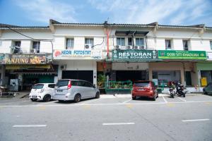um parque de estacionamento com carros estacionados em frente a um edifício em OYO 1224 Hotel Hajah Rohayah em Tanjung Malim