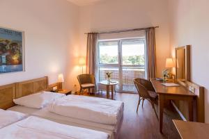 a hotel room with two beds and a desk and a window at Golfhotel & Restaurant Lindenhof in Bad Vilbel +37 photos