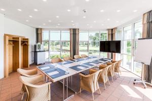 einen Konferenzraum mit einem langen Tisch und Stühlen in der Unterkunft Golfhotel & Restaurant Lindenhof in Bad Vilbel
