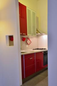 een keuken met rode kasten en een fornuis bij Rosalmar B&B in Palermo