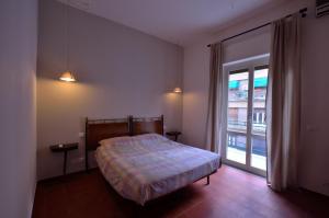 een slaapkamer met een bed en een groot raam bij Rosalmar B&B in Palermo