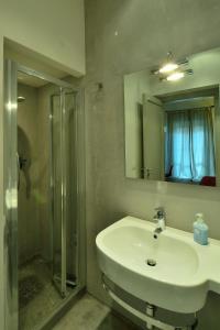 uma casa de banho com um lavatório, um chuveiro e um espelho. em Rosalmar B&B em Palermo