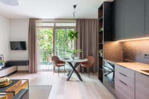 a kitchen and dining room with a table and chairs at Modern boutique apartment in the city center in Druskininkai