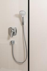 a shower with a shower head on a wall at Modern boutique apartment in the city center in Druskininkai