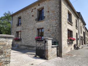 a stone building with flower boxes on the side of it at La chouette au bouleau in Hargnies