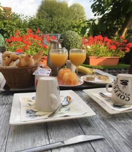 a table with a breakfast of bread and orange juice at Khon Thai's House Brugge in Bruges