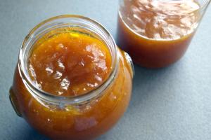 a jar of orange jam sitting on a table at Anthemis Rooms in Kokkari