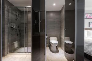 a bathroom with a toilet, sink, and shower at Lakeshore Hotel Yilan in Yilan City