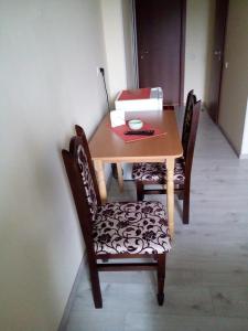 einem Esstisch mit 2 Stühlen und einer Schachtel darauf in der Unterkunft Central Studio in Ternopil