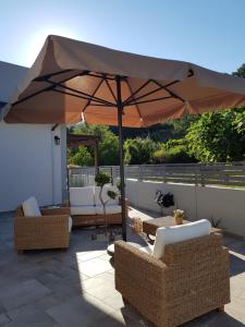 a large umbrella sitting on a patio with chairs and an umbrella at Evmelia Kakopetria Suites in Kakopetria