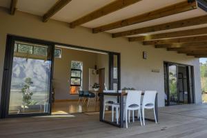 a dining room and living room with a table and chairs at Opstal Stay in Rawsonville