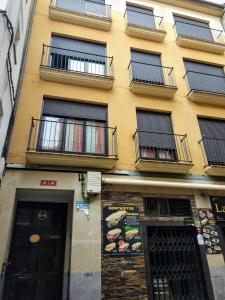 un edificio amarillo con balcones en un lateral en Los Tejados de Laurel en Logroño