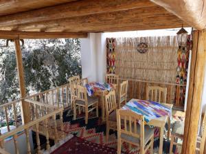 a porch with tables and chairs on a balcony at KHIVA ABDULLA Guest House in Khiva