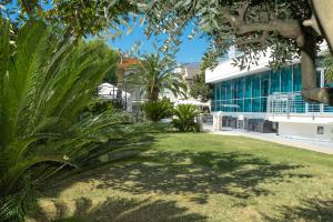 a park in front of a building with palm trees at Hotel Haus Charlotte in San Benedetto del Tronto