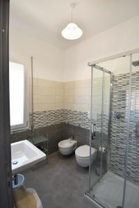 La salle de bains est pourvue de 2 toilettes, d'une baignoire et d'un lavabo. dans l'établissement B&B Centrale, à Tortolì