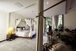 ein Schlafzimmer mit Himmelbett und Balkon in der Unterkunft Guilin Crystal Crescent Moon Hotel in Guilin