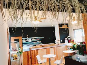 a restaurant with two tables and chairs in a room at ALOALO BEACH 川平 in Fukai
