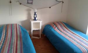 ein Schlafzimmer mit 2 Betten und einer Lampe auf einem Tisch in der Unterkunft Chambres d'hôtes à CUILLÉ in Cuillé