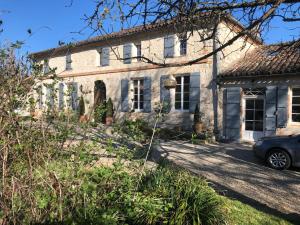 an old house with a car parked in front of it at Le Farat Bed & Breakfast in Auvillar